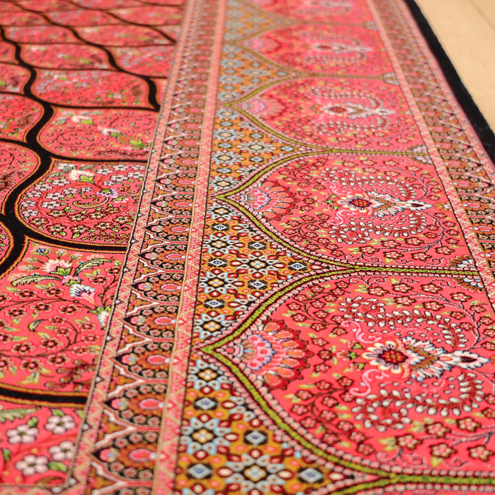 鮮やかな赤と複雑な模様が特徴の手織りペルシャ絨毯が床に広がり、ギャッベの専門店通販で取り扱うウールラグの織り目が際立っている。