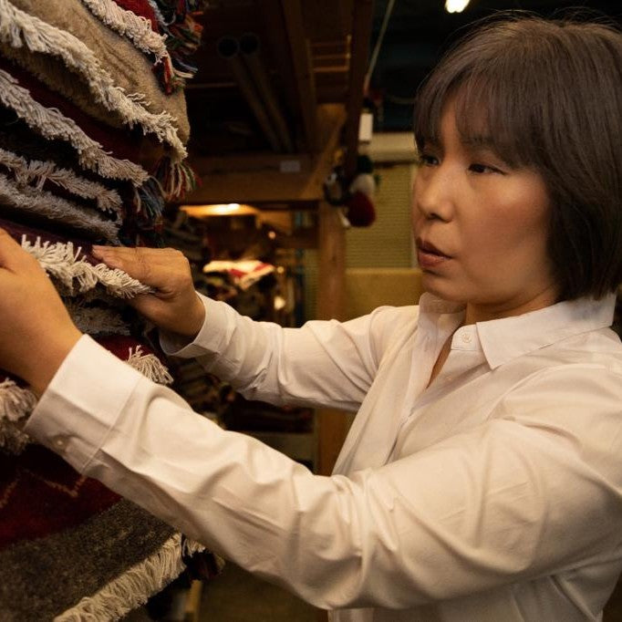 絨毯を見比べている日本人店長