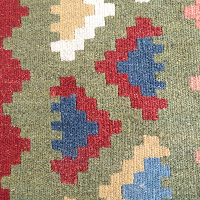 緑を基調に赤や青の幾何学模様が描かれた手織りのギャッベラグが、ペルシャ絨毯専門店の通販で見つかる。