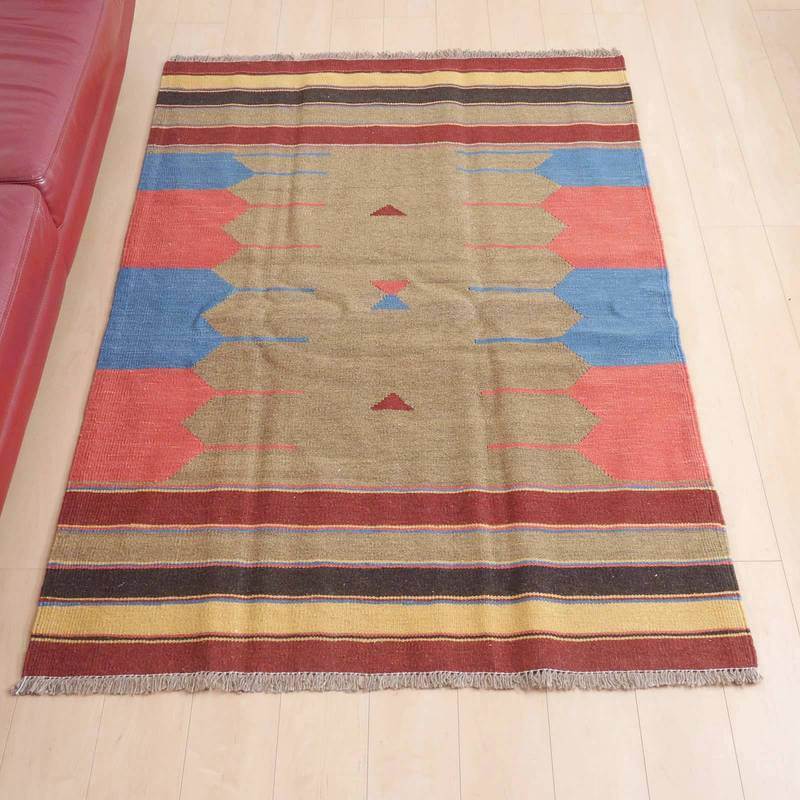 キリム・シラーズ/カシュガイ 184×127cm(KL-104)は、レッドとブルーの色調が鮮やかな手織りのギャッベラグが、ウール素材のぬくもりを感じさせながらリビングの床に広がっている。