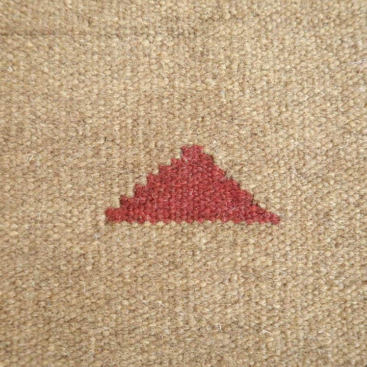 暖かみのあるウール素材に手織りで施された赤い三角模様が印象的なギャッベラグが見える。