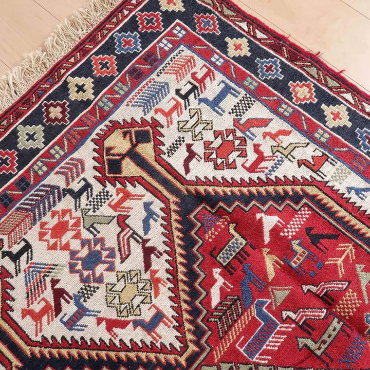 色彩豊かな幾何学模様が特徴的なギャッベラグが床に広がり、手織りウールの風合いとペルシャ絨毯の伝統が際立っています。