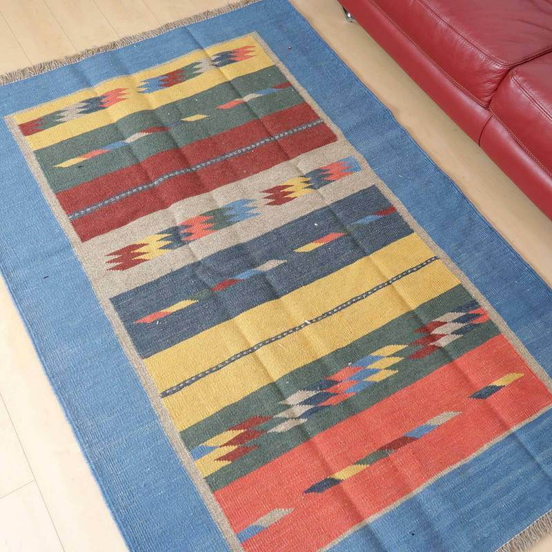 多彩な模様と鮮やかな色合いが特徴の手織りギャッベラグがリビングの床に敷かれており、ペルシャ絨毯専門店の通販で購入可能です。