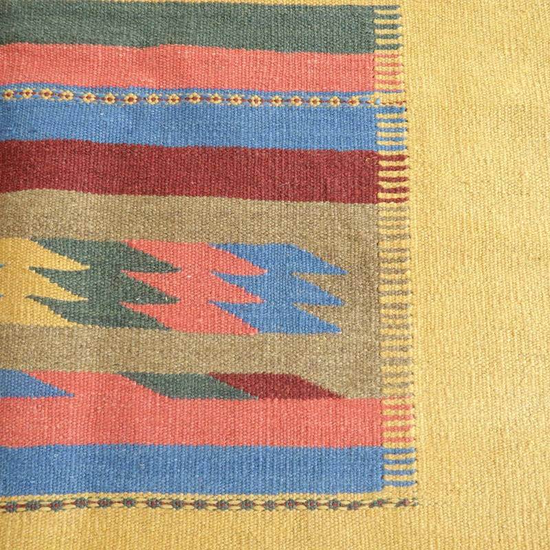 色彩豊かな手織りのギャッベラグが、幾何学模様とともに温かみあるウールの質感を見せています。