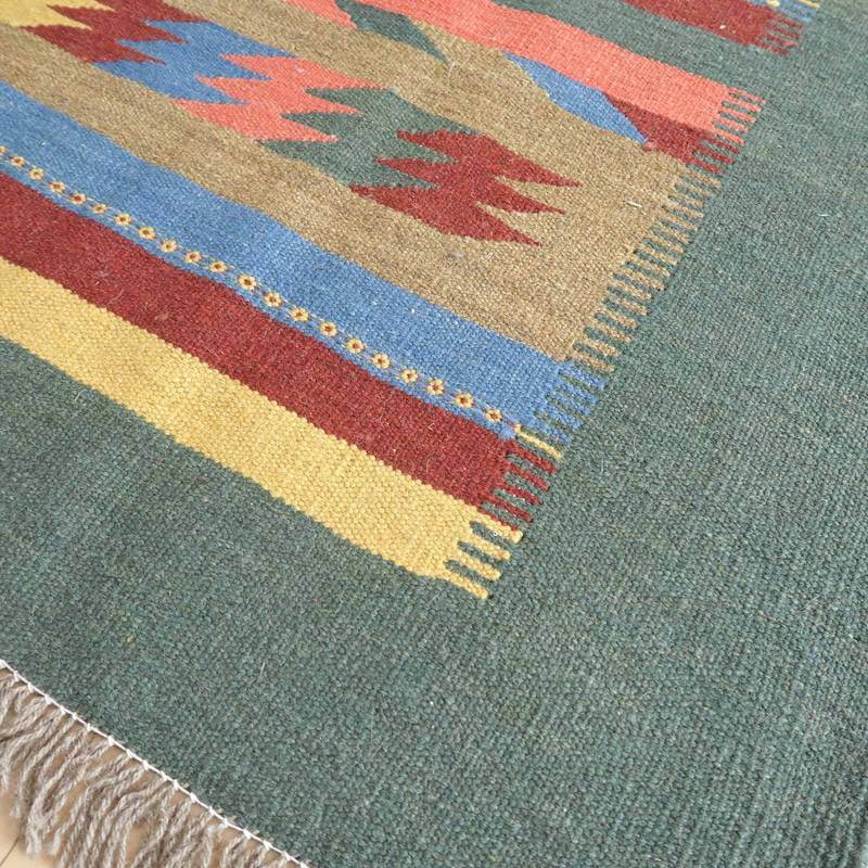 色鮮やかな模様と繊細な織り目が魅力のウール製ギャッベラグが床に広がり、異国情緒あふれるペルシャ絨毯の風合いが感じられる。