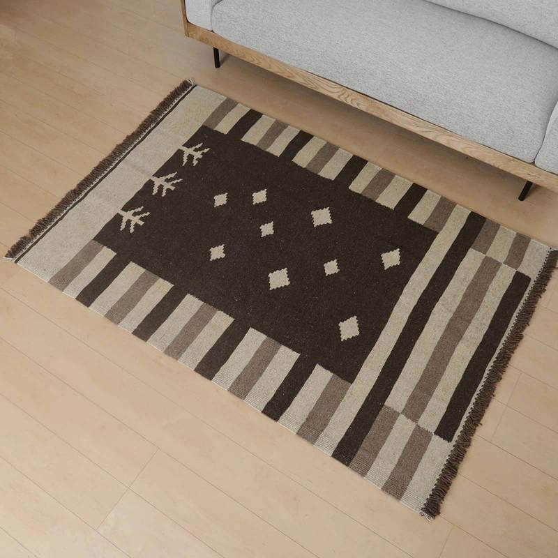 手織りのウールで丁寧に作られたギャッベラグが、温かみのあるペルシャ絨毯の専門店から通販され、落ち着いた色調でリビングの床に美しく敷かれている。