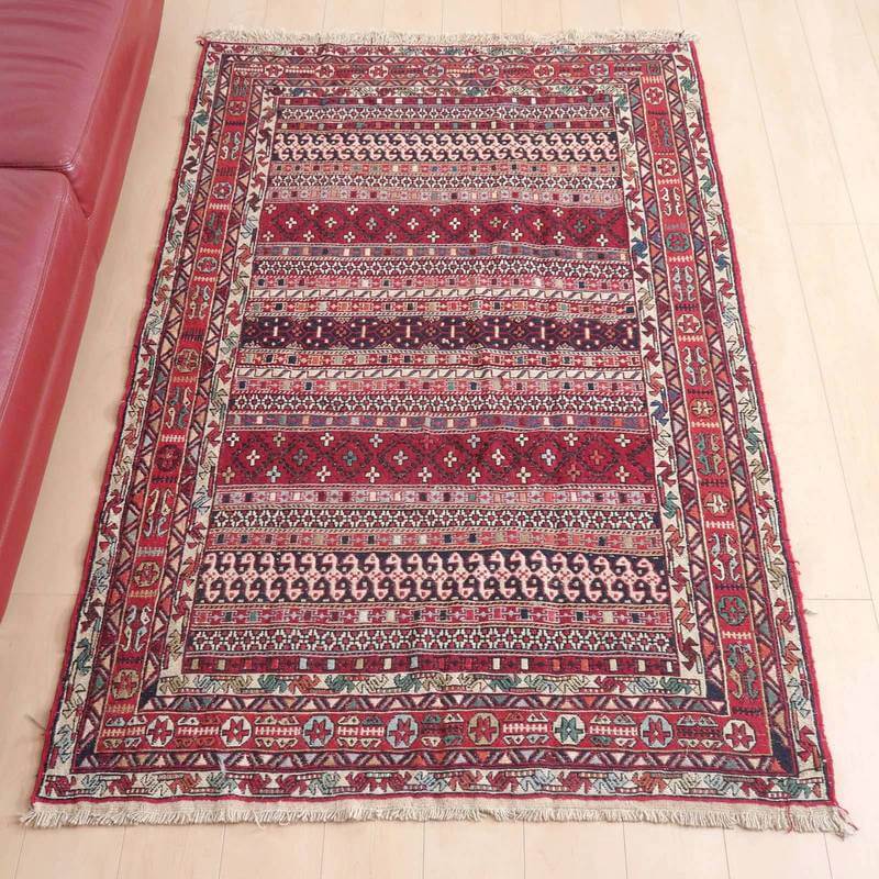 キリム・アゼルバイジャン193×124cm(KL-92)は、レッドのペルシャ絨毯が床に敷かれ、伝統的な手織り模様とウールの温かみがリビングを彩っています。