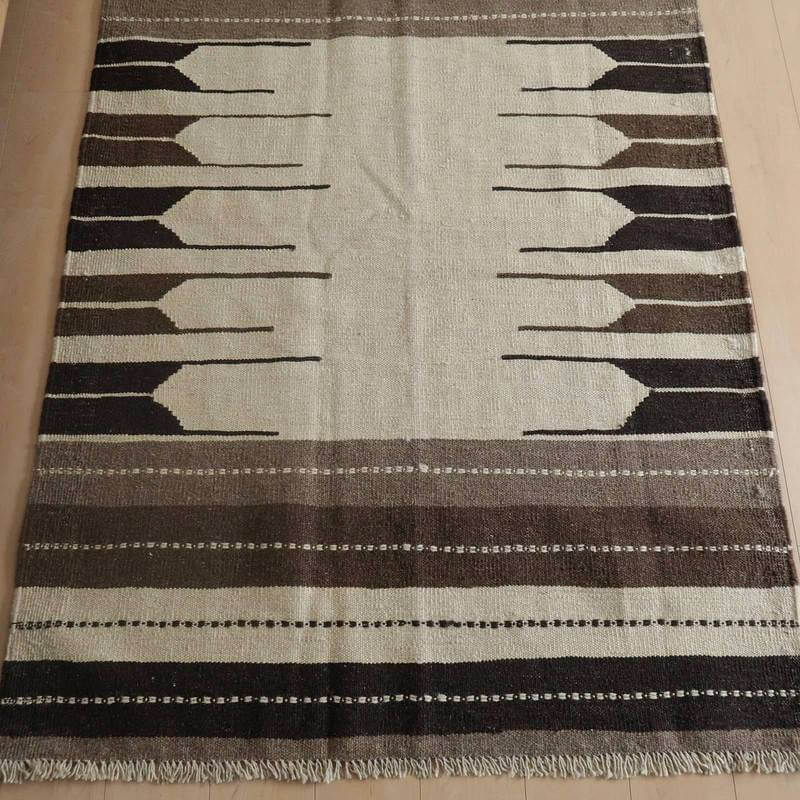 手織りのウール素材を使用したギャッベラグは、ブラウンとベージュのグラデーションが玄関の床に美しく調和している。