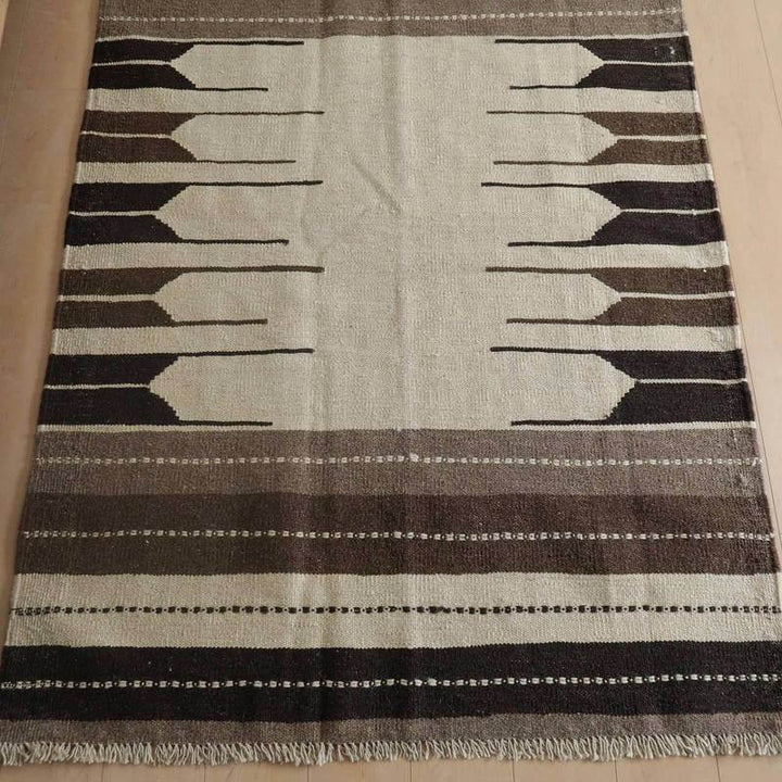 手織りのウール素材を使用したギャッベラグは、ブラウンとベージュのグラデーションが玄関の床に美しく調和している。