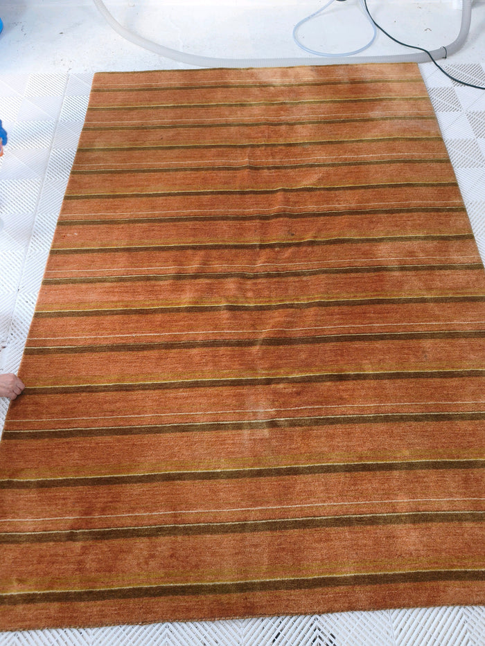 洗浄前のギャッベ全体。赤茶色の地に、濃い茶色と細い生成り色の横縞が入っている