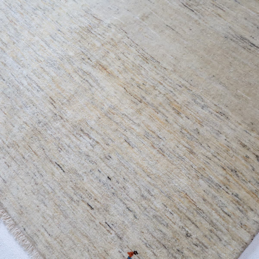 ギャッベHL-12947 端のアップ 毛足の厚みと織りの表情、無染色ウールの羊色ベースに動物モチーフ（カシュクリ手織り）