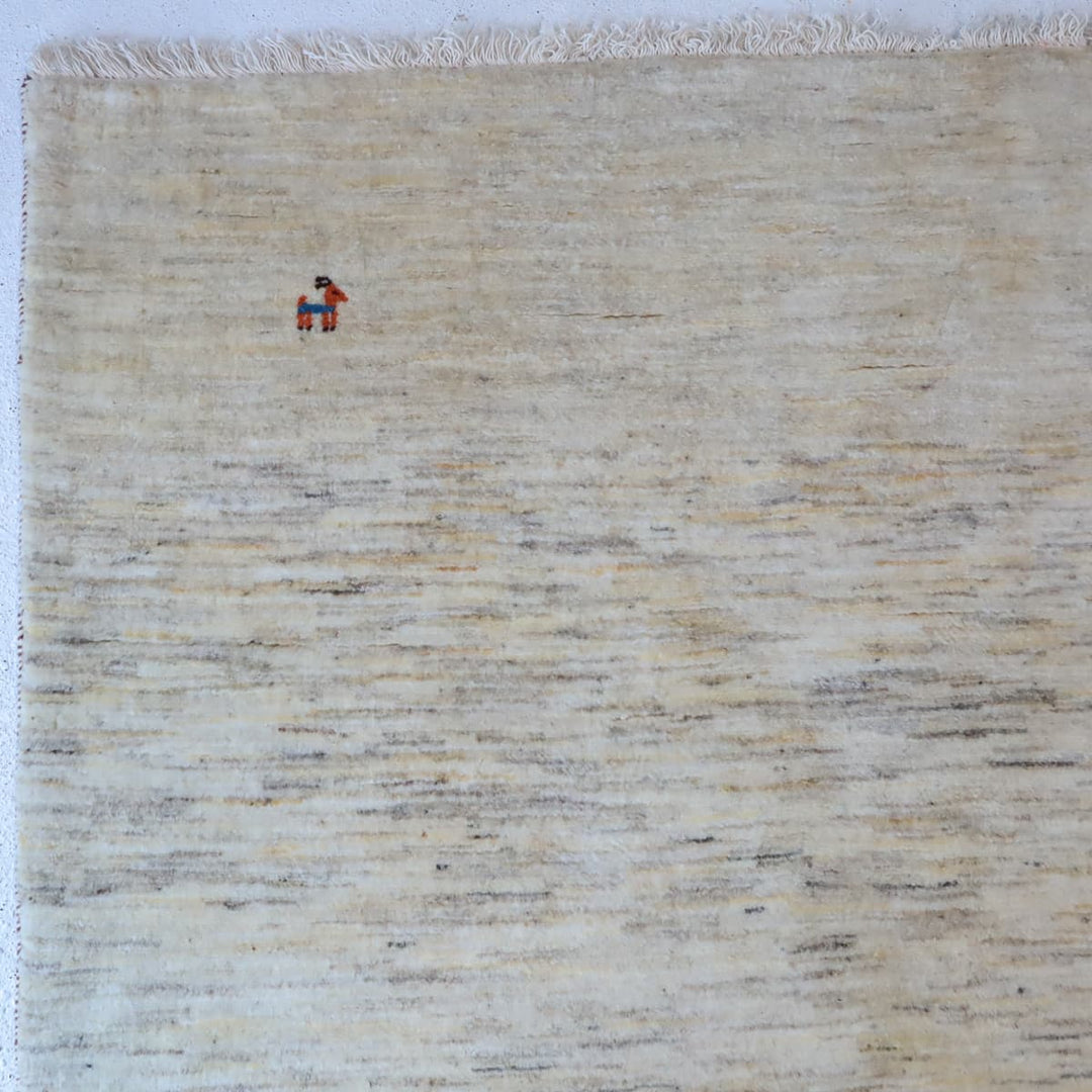 ギャッベHL-12947 上部のデザイン 無染色ウールのナチュラルな羊色と、左上の小さな動物モチーフ（カシュクリ手織り）