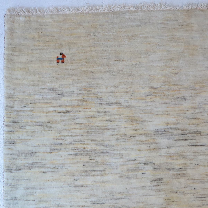 ギャッベHL-12947 上部のデザイン 無染色ウールのナチュラルな羊色と、左上の小さな動物モチーフ（カシュクリ手織り）