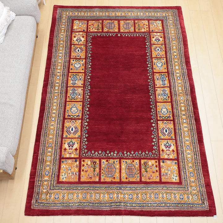 赤を基調とした伝統的な柄の絨毯が床に敷かれている様子