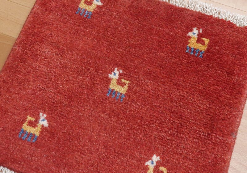 Rug with animal motifs in red — shown on the floor
