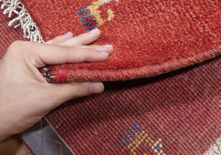 Rug — edge lifted to show the pile and thickness