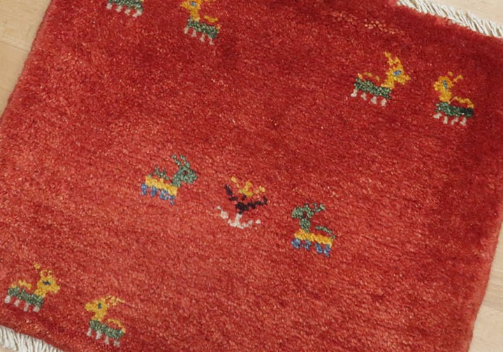 Rug with animal motifs in red, green and yellow — weave and texture