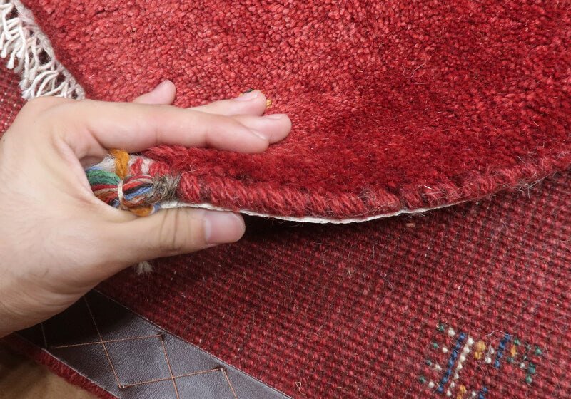 Rug — edge lifted to show the pile and thickness