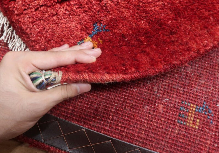 Patterned rug — edge lifted to show the pile and thickness