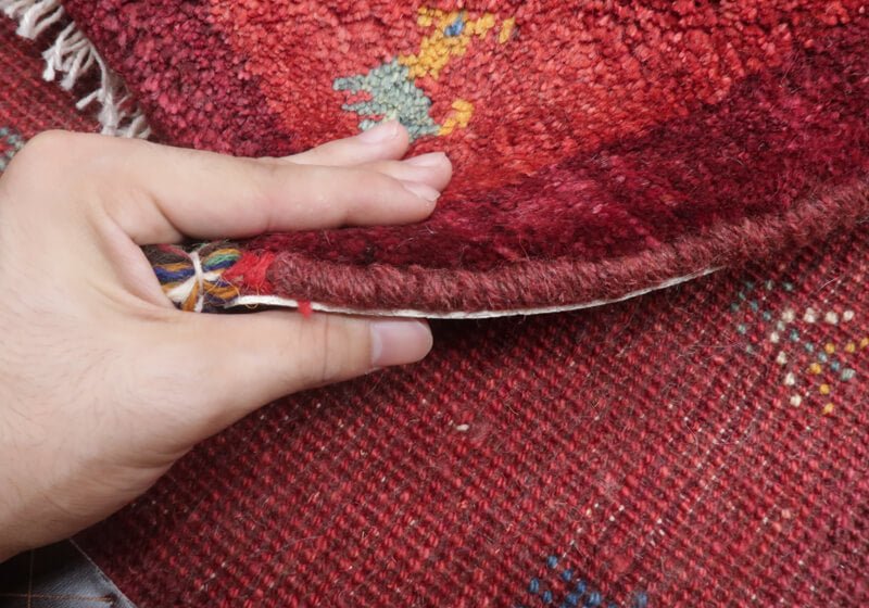 Rug — edge lifted to show the pile and thickness