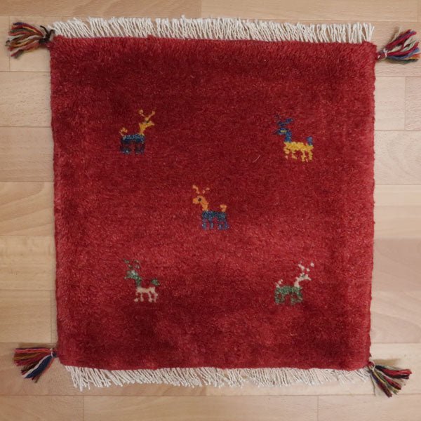 ギャッベ 43×42cm（HP-36788）は、赤いウールの手織りギャッベラグが床に敷かれ、カラフルな動物モチーフが温かみを添えている。