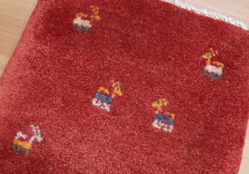Rug with animal motifs in red — shown on the floor