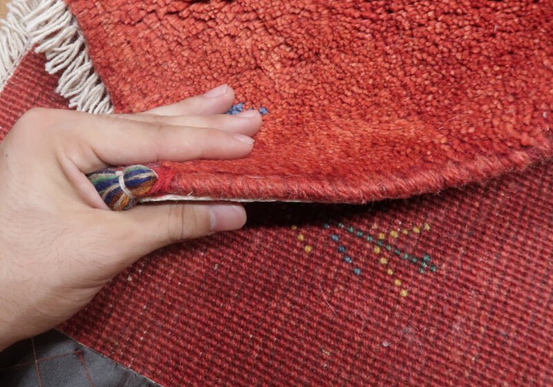Rug — edge lifted to show the pile and thickness
