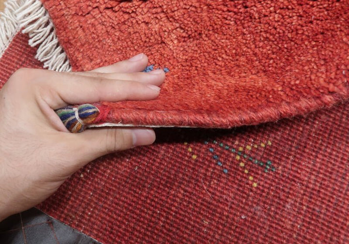 Rug — edge lifted to show the pile and thickness