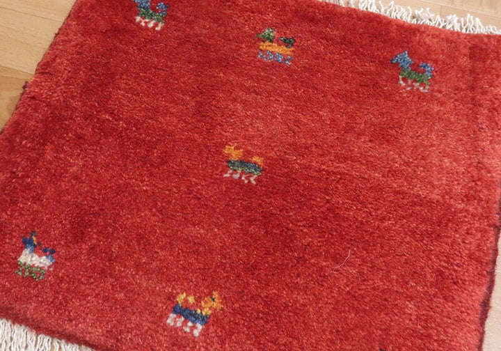 Rug with animal motifs in red — shown on the floor