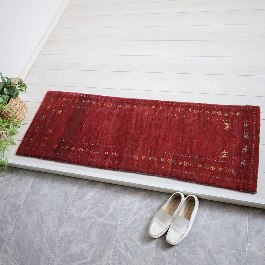 ギャッベ／カシュクリ　136×50cm（HR-11998）は、赤いウールの手織りギャッベが玄関に敷かれ、ペルシャ絨毯の専門店ならではの暖かみが感じられる。