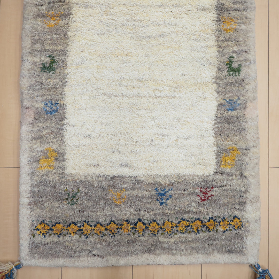 グレーとベージュの縁取りに色とりどりの動物模様が入ったシンプルな敷物