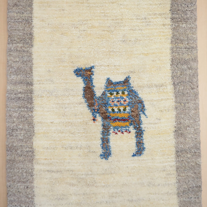ベージュとグレーの縁取りがある敷物の中央にカラフルな抽象的な動物の模様が描かれている