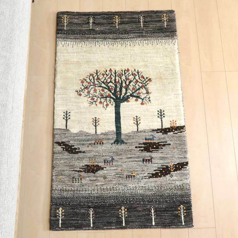 ギャッベ／カシュクリ 134×79cm（HS-77938）は、手織りのギャッベラグが床に敷かれ、ウール素材の温かみとペルシャ絨毯特有の美しい木のデザインが際立っている。