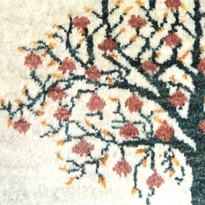 手織りのウール製ギャッベラグに描かれた、赤い花と枝の模様が生き生きと浮かび上がっている。