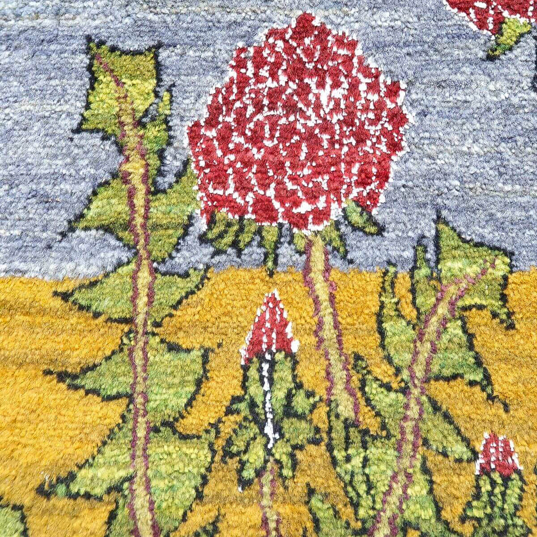 手織りのギャッベラグに描かれた赤い花と緑の葉が、ウールの温かみある素材感とともに鮮やかに際立っている。