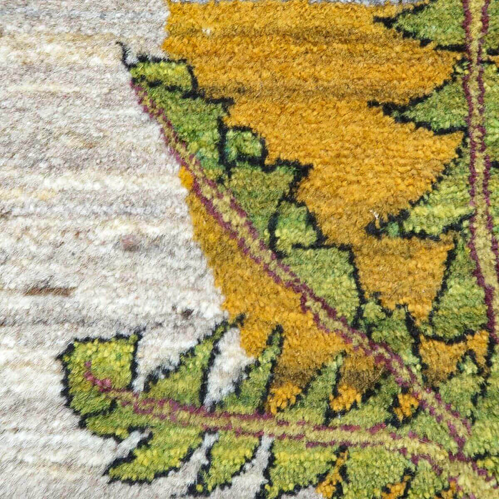 緻密に手織りされたペルシャ絨毯のギャッベが、鮮やかな黄色と緑の模様でウールの柔らかな質感が際立っている。