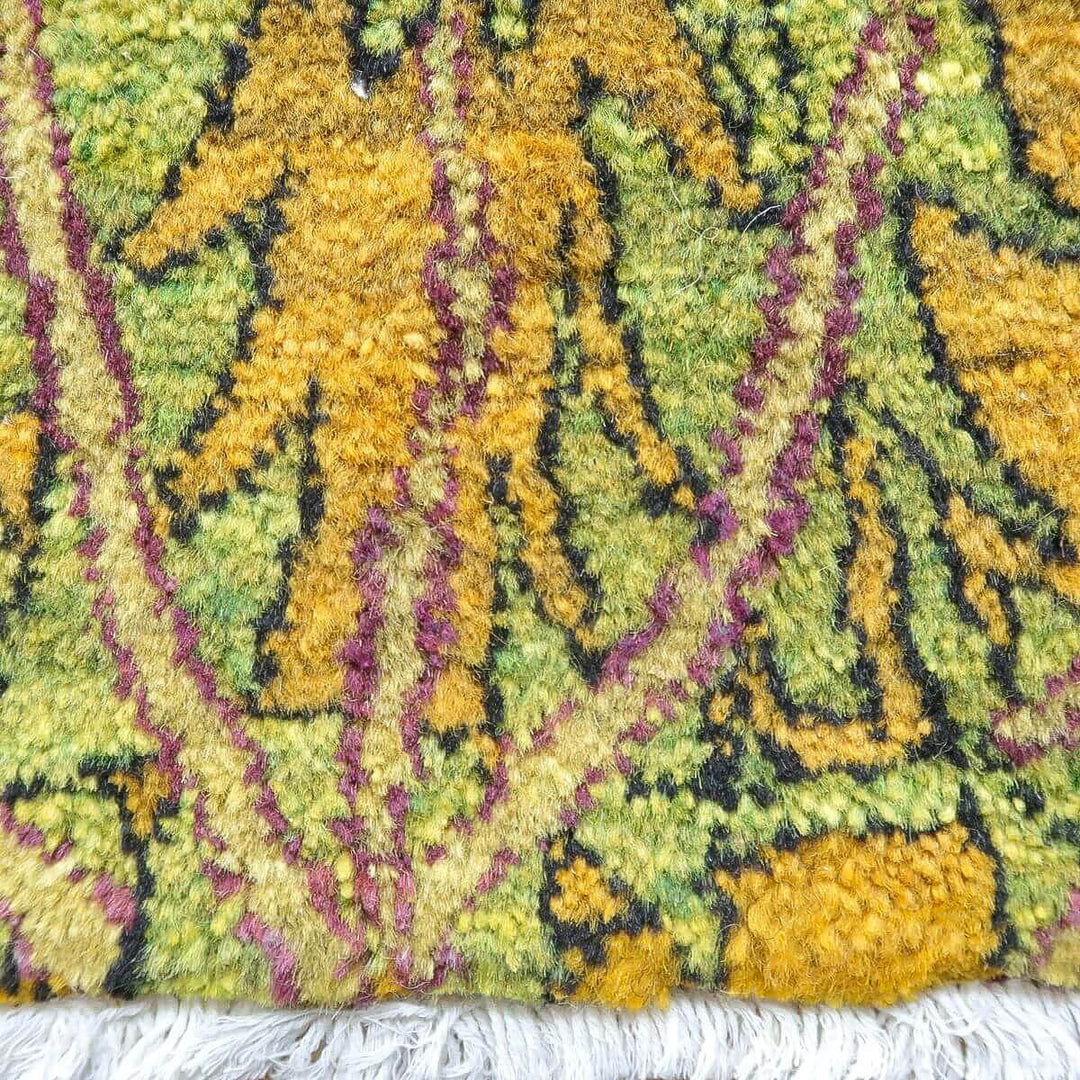 色鮮やかな緑と黄の模様が特徴のペルシャ絨毯、手織りのウールラグの繊細な織り目が際立っている。