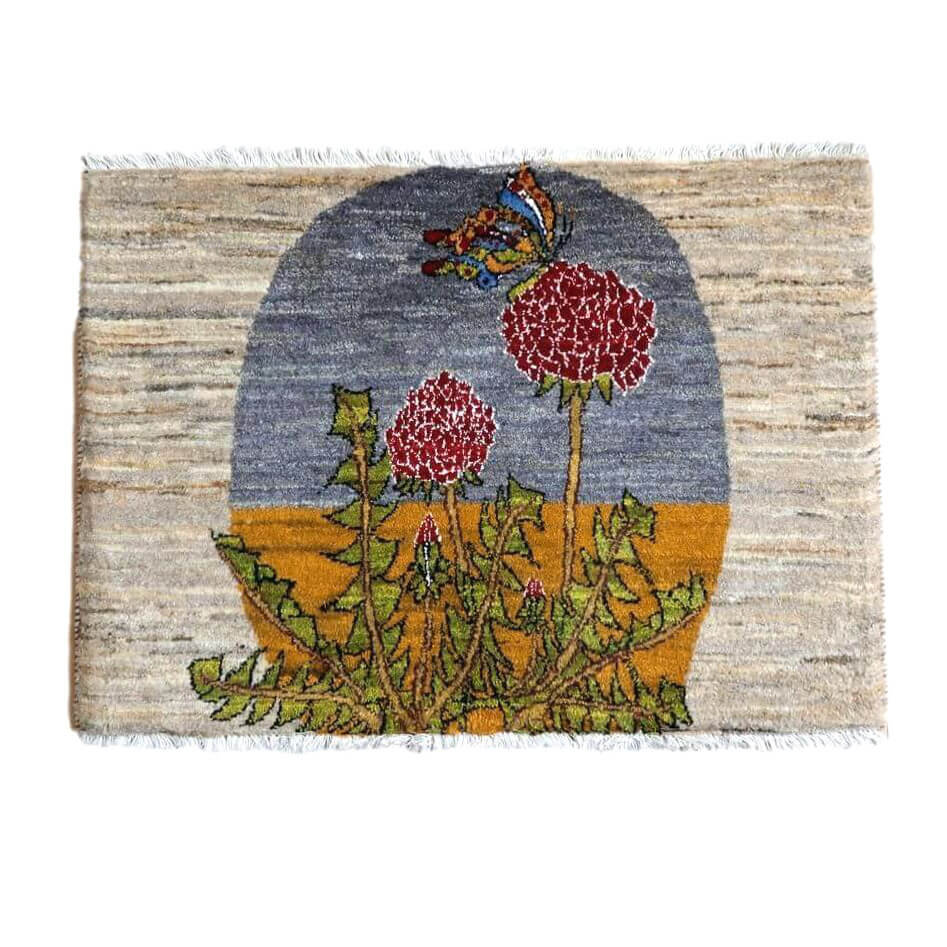 色鮮やかな花と蝶が描かれた、ウール素材の手織りギャッベラグが床に広がり、ペルシャ絨毯専門店の通販で見つかります。