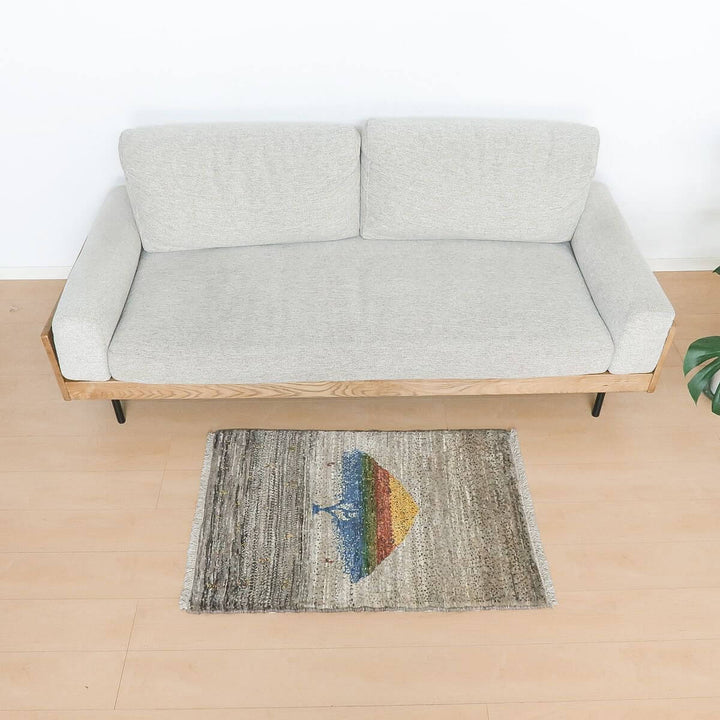 ギャッベ（カシュクリ）　98×67cm（HSS-11161）は、グレーのソファの前に、色彩豊かなパターンが特徴の手織りウールギャッベラグが敷かれている。