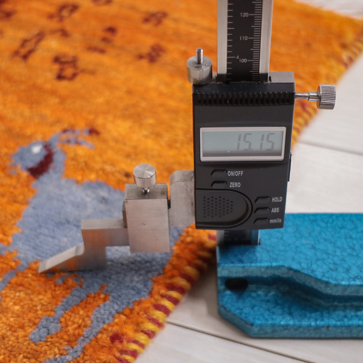 手織りのウール素材が魅力的なギャッベのラグが精密に計測され、ペルシャ絨毯専門店の通販で安心して購入できる厚みが確認できる。