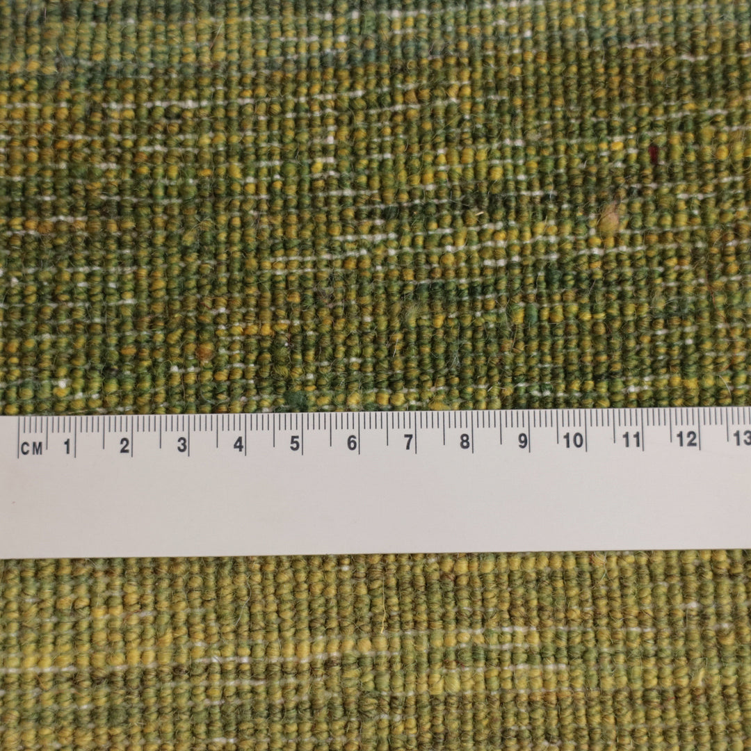 緑の微細な色合いが美しい手織りウールのギャッベラグが、定規とともにその織りの密度を際立たせている。