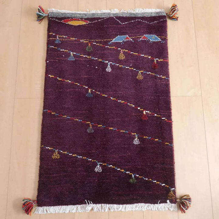 ギャッベ／ルリバフ 95×62cm（HSS-72444）は、深い赤の色調に、手織りで丁寧に表現された模様が美しいギャッベのラグが床に敷かれている。