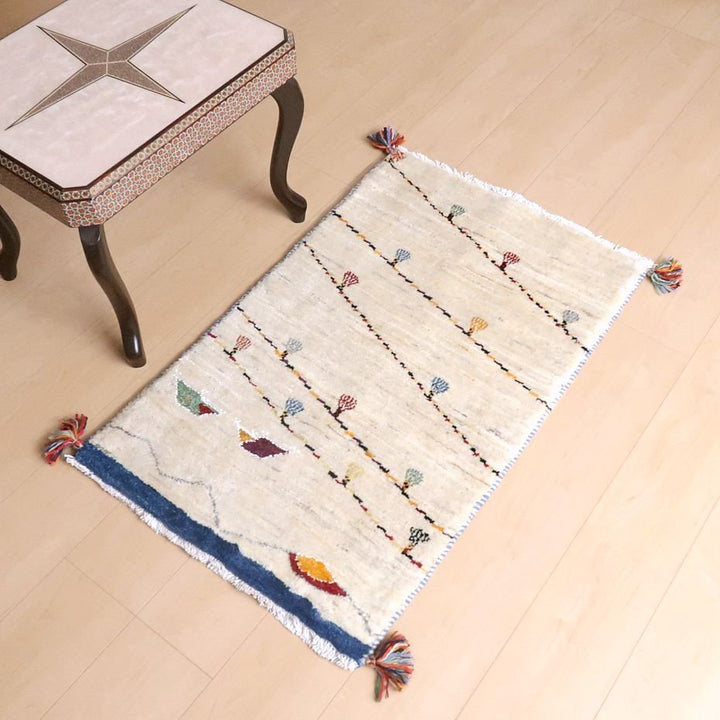 手織りのウール製ギャッベラグが床に敷かれており、色とりどりの模様がペルシャ絨毯専門店の通販で購入可能な温かみを添えている。