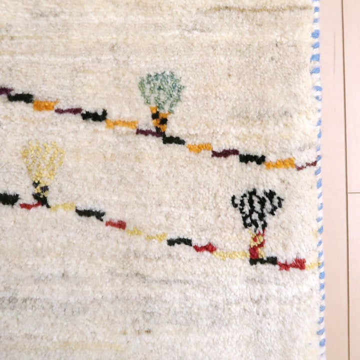 手織りのウール素材で作られたペルシャ絨毯専門店のギャッベラグが、カラフルな模様と柔らかな質感で床に広がっている。