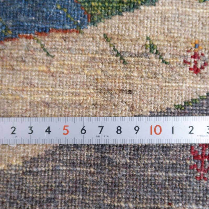 手織りのウールで丁寧に作られたギャッベラグの織り目が、定規とともに詳細に示されている。