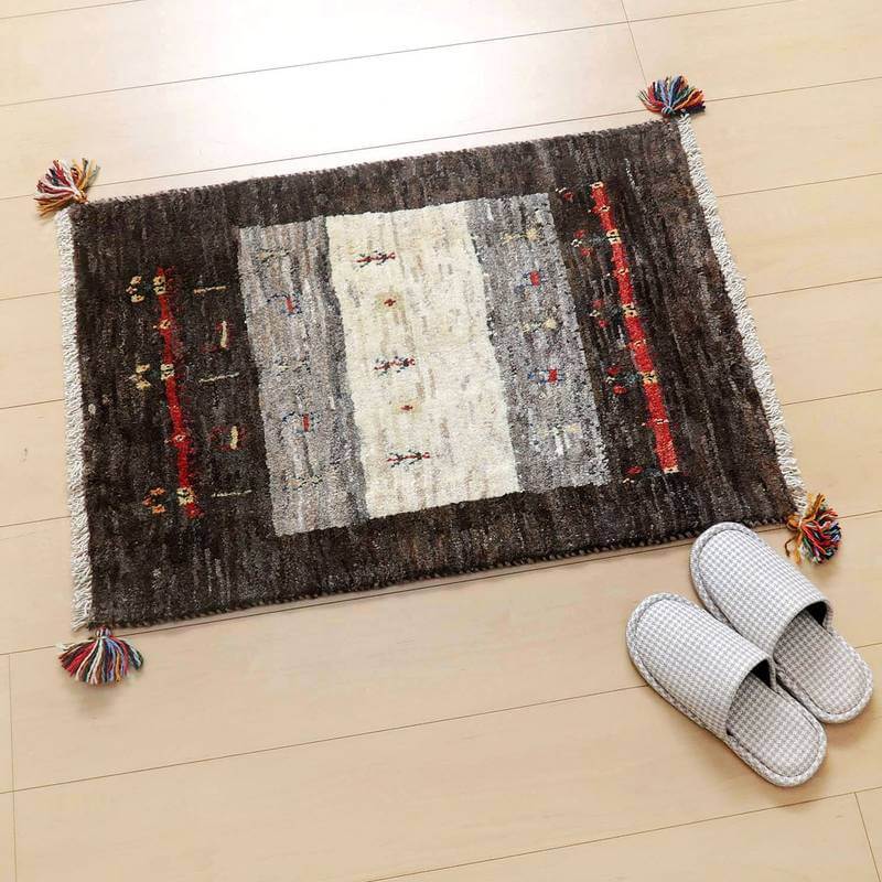 ギャッベ／カシュクリ 83×57cm（HSS-45338）は、落ち着いた色合いの手織りギャッベラグが玄関の木製フローリングに敷かれ、伝統的なペルシャ絨毯の魅力が漂っています。
