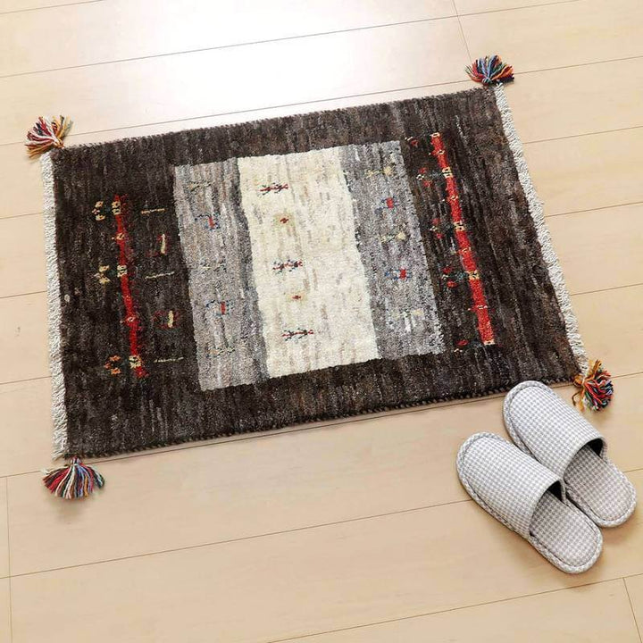 ギャッベ／カシュクリ 83×57cm（HSS-45338）は、落ち着いた色合いの手織りギャッベラグが玄関の木製フローリングに敷かれ、伝統的なペルシャ絨毯の魅力が漂っています。