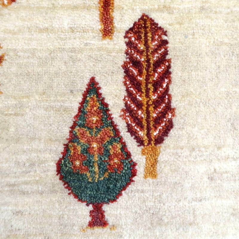 緻密に手織りされたウールのギャッベラグが、ペルシャ絨毯専門店の通販で人気の木々模様を鮮やかに描き出しています。