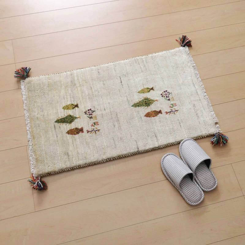 木目調の床に置かれた、手織りのギャッベラグが落ち着いた雰囲気を醸し出し、ペルシャ絨毯の専門店で通販可能なウール素材が柔らかく映えている。