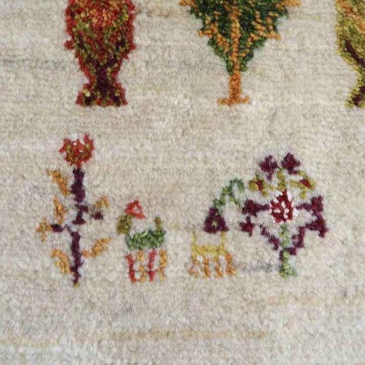 手織りのギャッベラグは、ウールの質感に鮮やかな植物模様が丁寧に描かれ、ペルシャ絨毯専門店の通販でその織り目が際立っている。